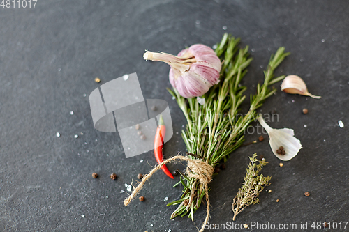 Image of rosemary, garlic and chili pepper on stone surface