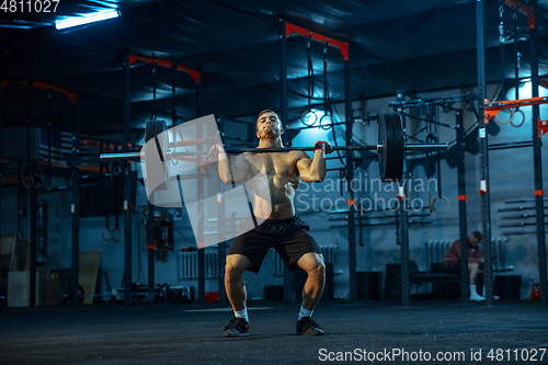 Image of Caucasian man practicing in weightlifting in gym