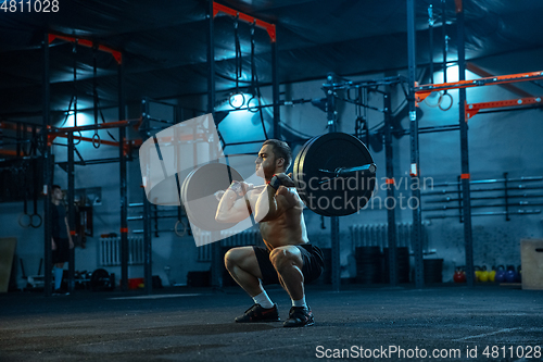 Image of Caucasian man practicing in weightlifting in gym