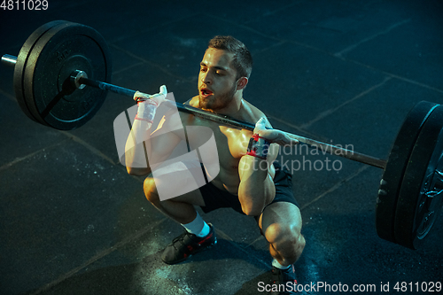 Image of Caucasian man practicing in weightlifting in gym