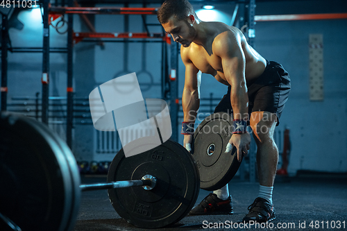 Image of Caucasian man practicing in weightlifting in gym