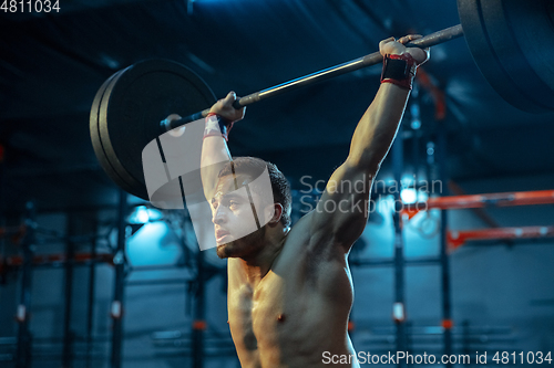 Image of Caucasian man practicing in weightlifting in gym