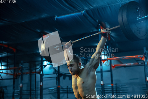 Image of Caucasian man practicing in weightlifting in gym