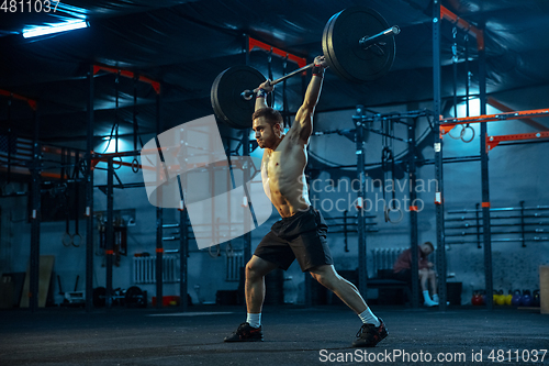 Image of Caucasian man practicing in weightlifting in gym