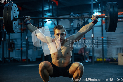 Image of Caucasian man practicing in weightlifting in gym