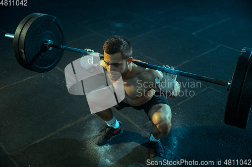 Image of Caucasian man practicing in weightlifting in gym