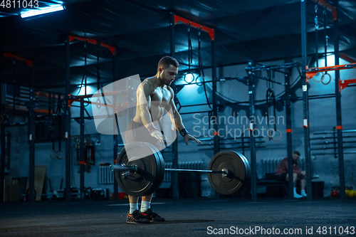 Image of Caucasian man practicing in weightlifting in gym