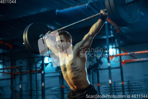 Image of Caucasian man practicing in weightlifting in gym