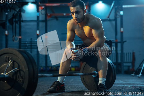 Image of Caucasian man practicing in weightlifting in gym