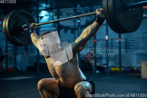 Image of Caucasian man practicing in weightlifting in gym