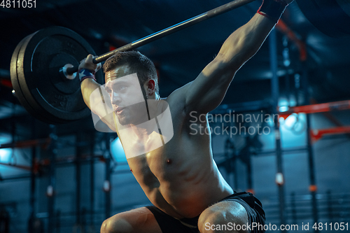 Image of Caucasian man practicing in weightlifting in gym