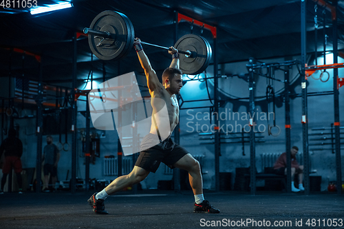 Image of Caucasian man practicing in weightlifting in gym