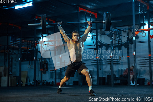 Image of Caucasian man practicing in weightlifting in gym