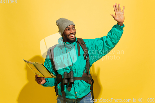 Image of Full length portrait of a cheerful young african tourist guy isolated on yellow background