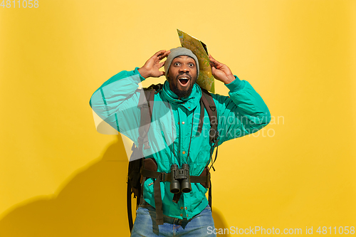 Image of Full length portrait of a cheerful young african tourist guy isolated on yellow background