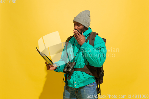 Image of Full length portrait of a cheerful young african tourist guy isolated on yellow background