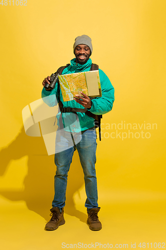 Image of Full length portrait of a cheerful young african tourist guy isolated on yellow background