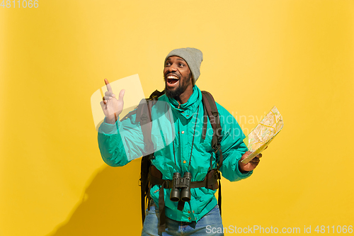 Image of Full length portrait of a cheerful young african tourist guy isolated on yellow background