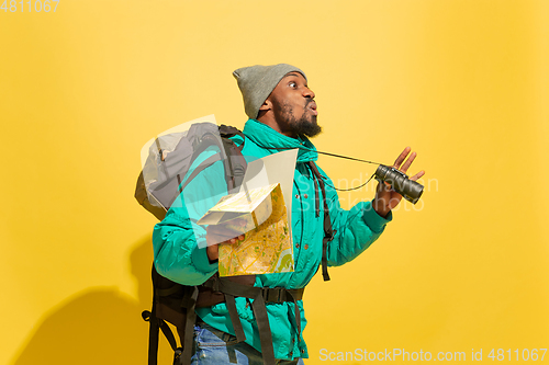 Image of Full length portrait of a cheerful young african tourist guy isolated on yellow background