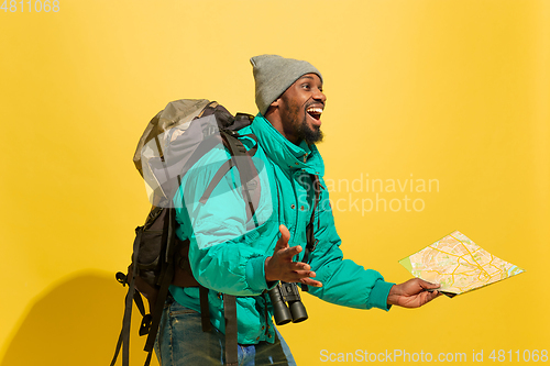 Image of Full length portrait of a cheerful young african tourist guy isolated on yellow background