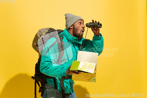 Image of Full length portrait of a cheerful young african tourist guy isolated on yellow background