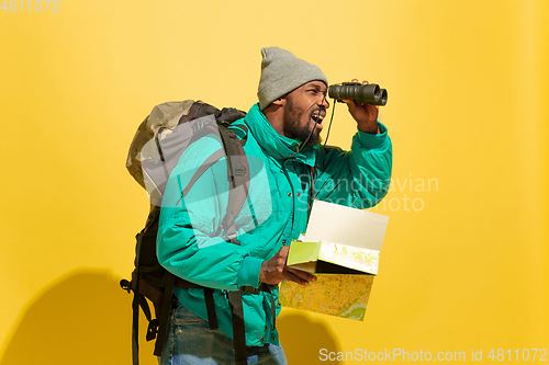 Image of Full length portrait of a cheerful young african tourist guy isolated on yellow background