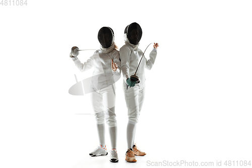 Image of Teen girls in fencing costumes with swords in hands isolated on white background