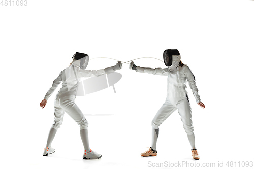 Image of Teen girls in fencing costumes with swords in hands isolated on white background