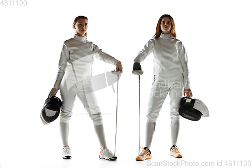 Image of Teen girls in fencing costumes with swords in hands isolated on white background