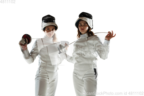 Image of Teen girls in fencing costumes with swords in hands isolated on white background