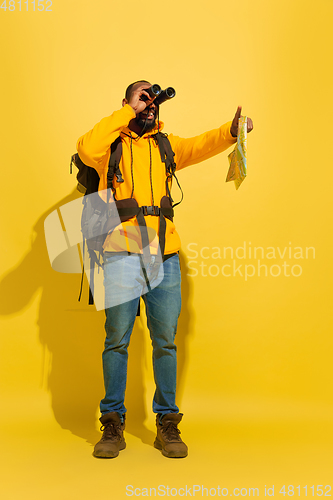 Image of Full length portrait of a cheerful young african tourist guy isolated on yellow background