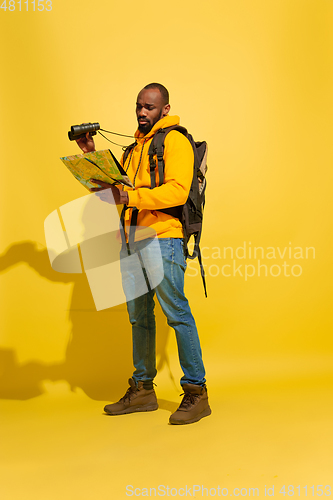 Image of Full length portrait of a cheerful young african tourist guy isolated on yellow background