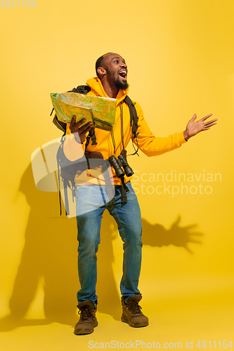 Image of Full length portrait of a cheerful young african tourist guy isolated on yellow background