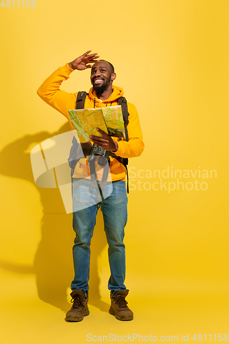 Image of Full length portrait of a cheerful young african tourist guy isolated on yellow background