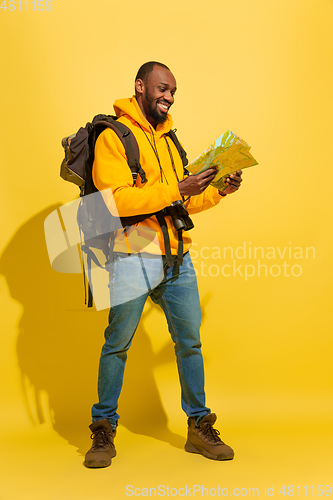 Image of Full length portrait of a cheerful young african tourist guy isolated on yellow background