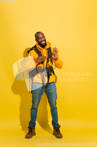 Image of Full length portrait of a cheerful young african tourist guy isolated on yellow background