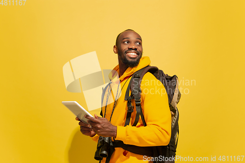 Image of Full length portrait of a cheerful young african tourist guy isolated on yellow background