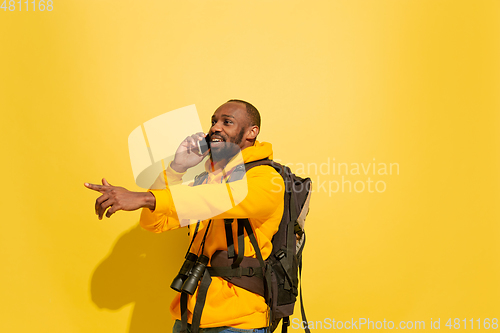 Image of Full length portrait of a cheerful young african tourist guy isolated on yellow background