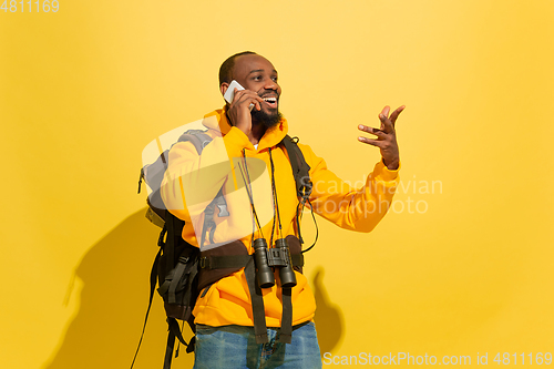 Image of Full length portrait of a cheerful young african tourist guy isolated on yellow background