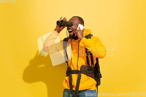 Image of Full length portrait of a cheerful young african tourist guy isolated on yellow background