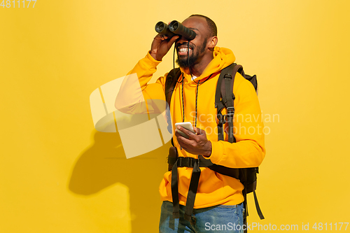 Image of Full length portrait of a cheerful young african tourist guy isolated on yellow background