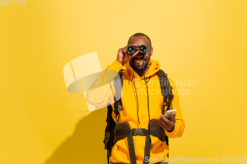 Image of Full length portrait of a cheerful young african tourist guy isolated on yellow background