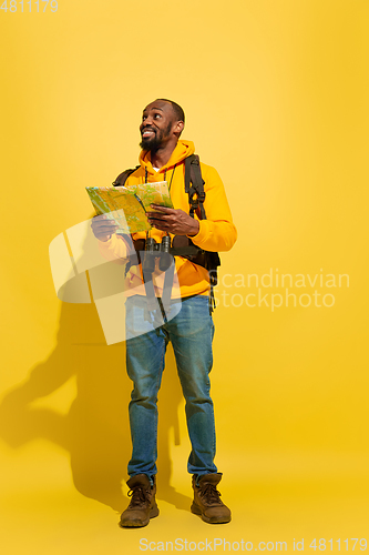 Image of Full length portrait of a cheerful young african tourist guy isolated on yellow background