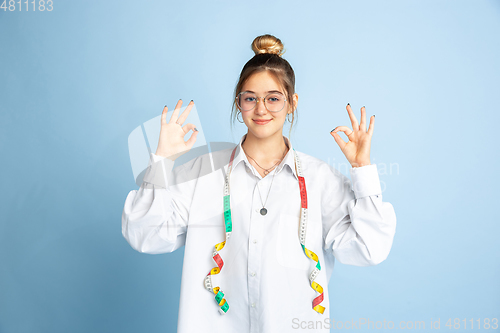 Image of Young girl dreaming about future profession of seamstress