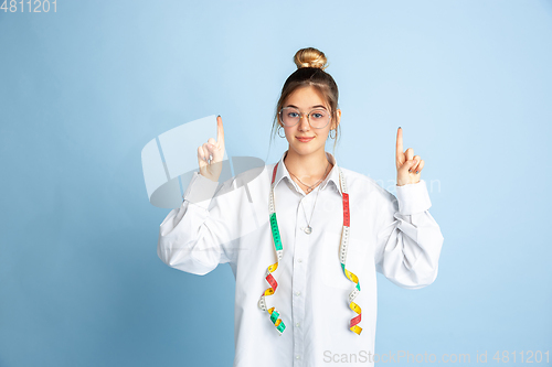 Image of Young girl dreaming about future profession of seamstress