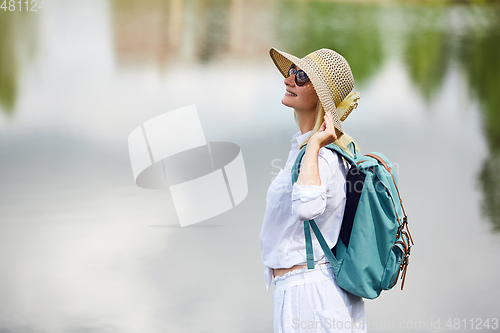 Image of Young woman resting near lake