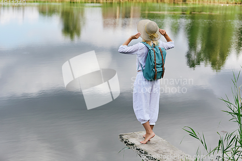 Image of Young woman resting near lake