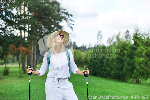 Image of young woman with nordic walk pols