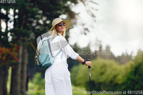 Image of young woman with nordic walk pols