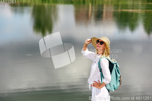 Image of Young woman resting near lake